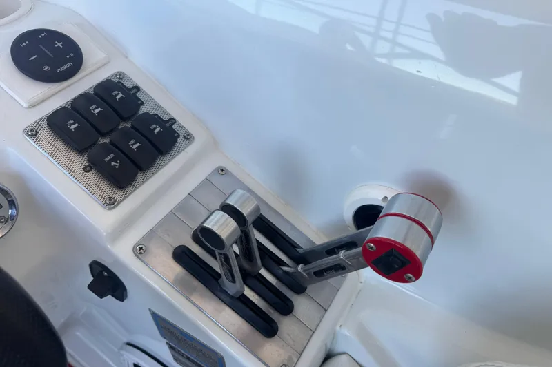 Slide: The Image of Control panel of a 2005 Baja 342 boat with throttle levers and switches. - 12