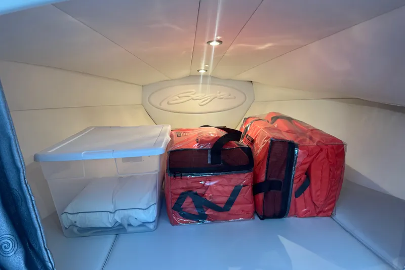 Slide: The Image of Interior storage of 2005 Baja 342 boat with red bags and a plastic container. - 20