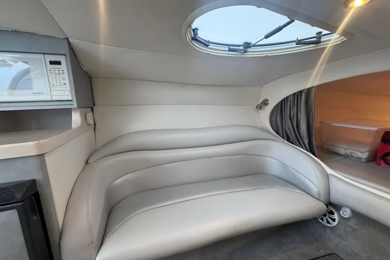 Slide: The Image of 2005 Baja 342 boat interior with gray seating, microwave, and skylight. - 22
