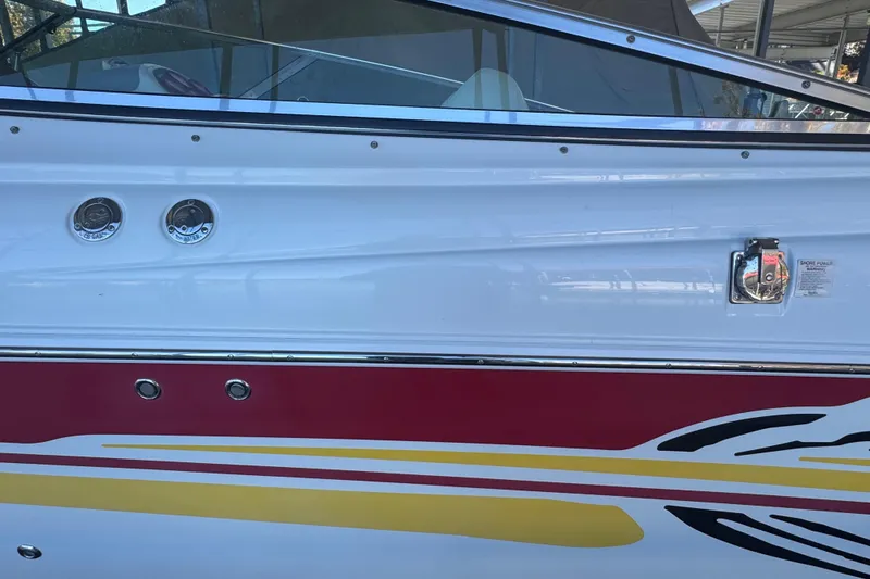 Slide: The Image of Side view of a 2005 Baja 342 boat with colorful graphics and fuel caps. - 28