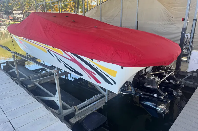 Slide: The Image of 2005 Baja 342 boat with red cover on a lift, featuring colorful graphics. - 35