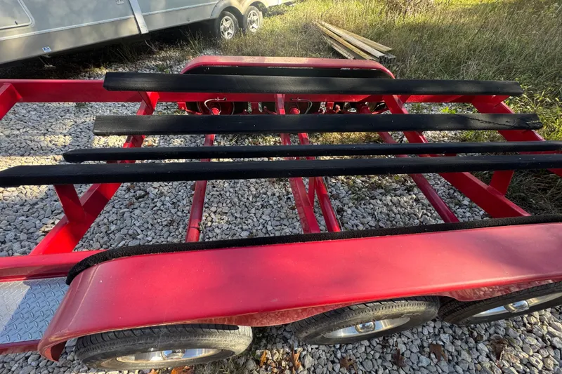 Slide: The Image of Red boat trailer for 2005 Baja 342 on gravel, with black supports. - 39