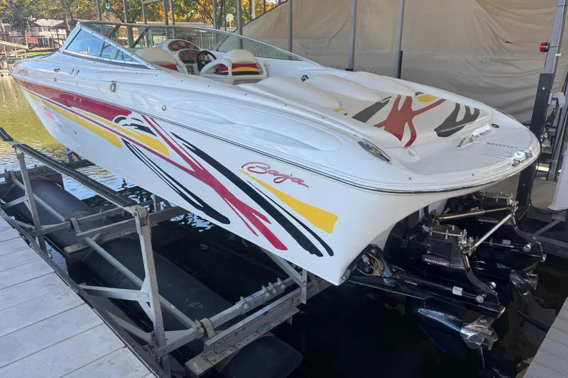Slide: The Image of 2005 Baja 342 speedboat with colorful graphics on a lift at a marina. - 5