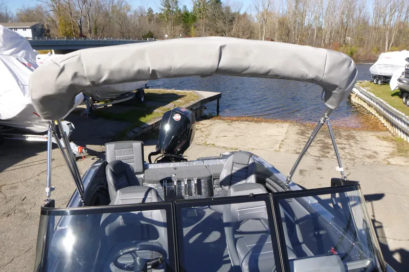 Slide: The Image of 2026 Ranger 2080MS boat with covered bimini top, docked near a lake. - 39