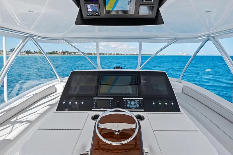 Slide: The Image of 2025 Viking 64 Convertible yacht helm with advanced navigation system on open sea. - 13