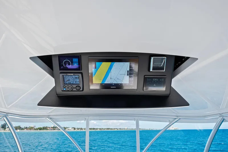 Slide: The Image of 2025 Viking 64 Convertible yacht navigation system with digital displays and ocean view. - 15