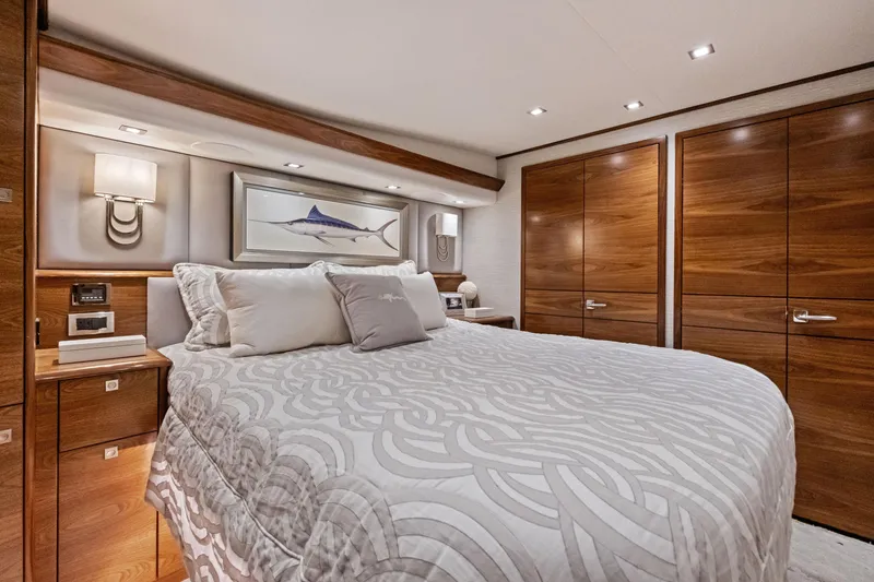Slide: The Image of Luxurious bedroom interior of 2025 Viking 64 Convertible yacht with elegant wood finishes. - 31