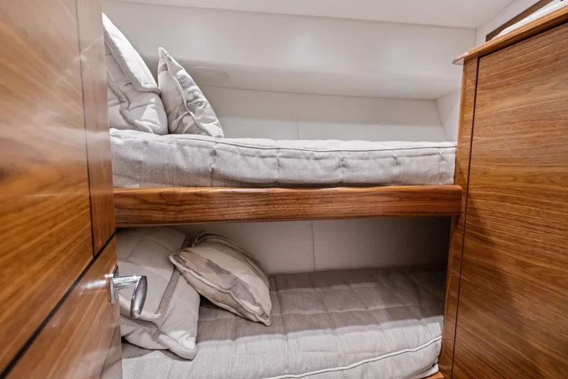 Slide: The Image of 2025 Viking 64 Convertible yacht interior with cozy wooden bunk beds. - 36
