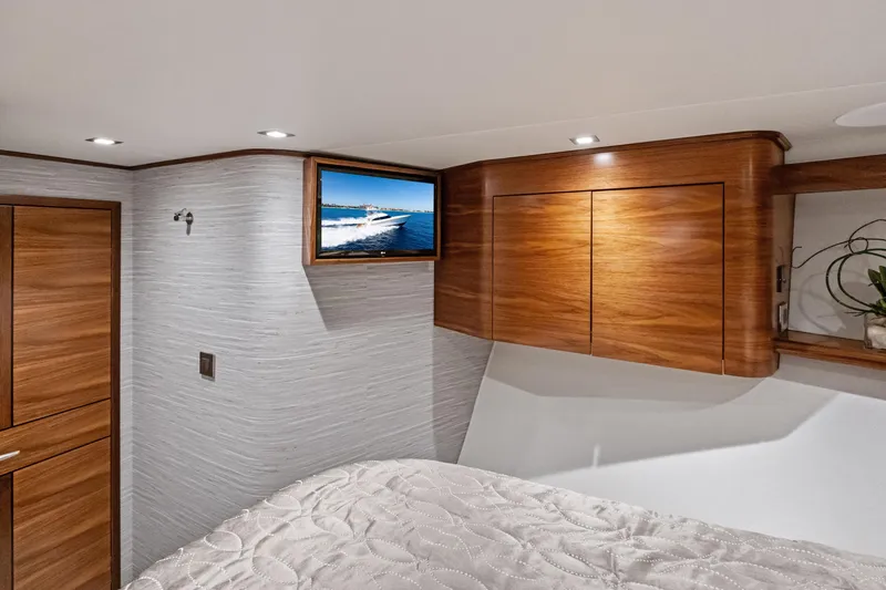 Slide: The Image of Luxurious interior of 2025 Viking 64 Convertible yacht with wood cabinetry and mounted TV. - 39