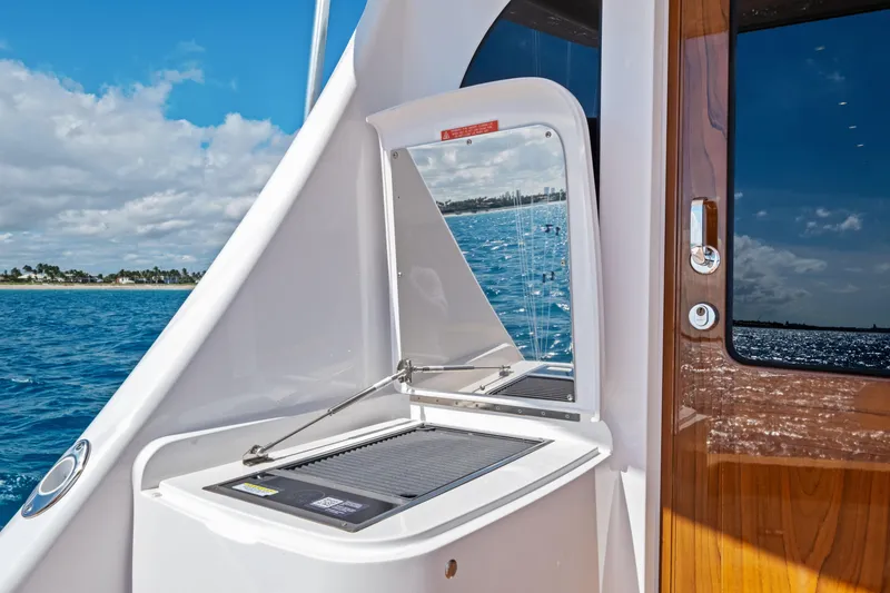 Slide: The Image of 2025 Viking 64 Convertible yacht with outdoor grill and ocean view. - 53