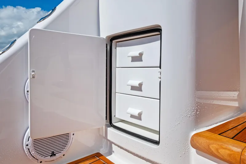 Slide: The Image of 2025 Viking 64 Convertible yacht storage compartment with open door and drawers. - 54