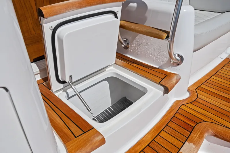 Slide: The Image of Open storage compartment on 2025 Viking 64 Convertible yacht with teak flooring. - 56