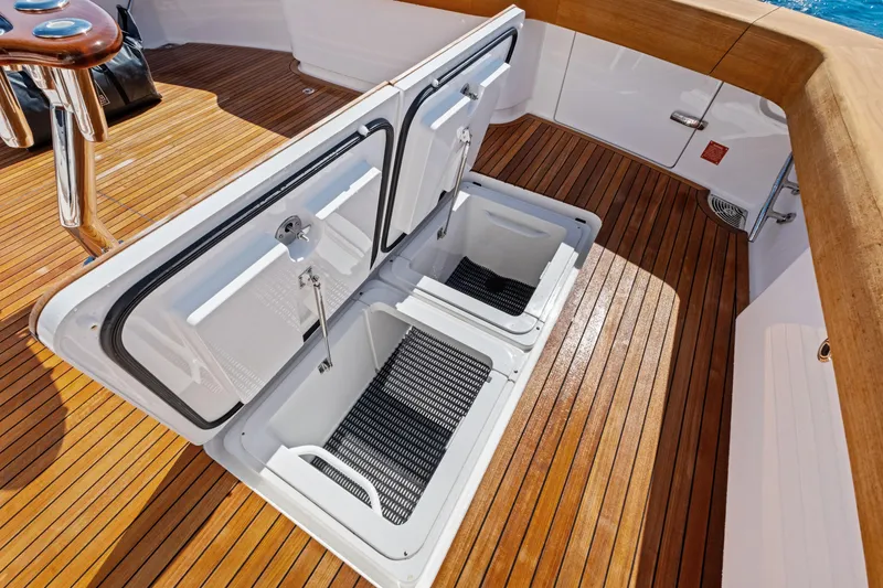Slide: The Image of Open storage compartments on 2025 Viking 64 Convertible yacht's teak deck. - 58