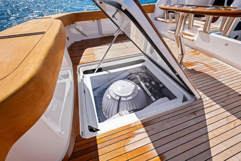 Slide: The Image of Open hatch on 2025 Viking 64 Convertible yacht deck, revealing mechanical equipment. - 59