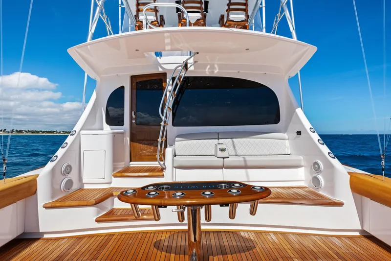 Slide: The Image of 2025 Viking 64 Convertible yacht with elegant deck and seating, set against a clear blue ocean. - 62