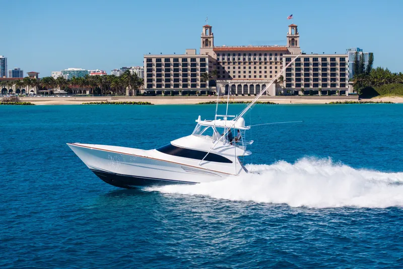 Slide: The Image of 2025 Viking 64 Convertible yacht cruising in blue waters near a grand waterfront building. - 8